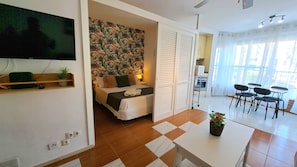 Ein Hotelzimmer mit einem Bett, einem Fernseher, einem Schreibtisch und einer Essecke mit Stühlen.