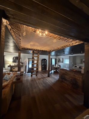 A spacious interior with a wooden ceiling, a dining area, and a kitchen.