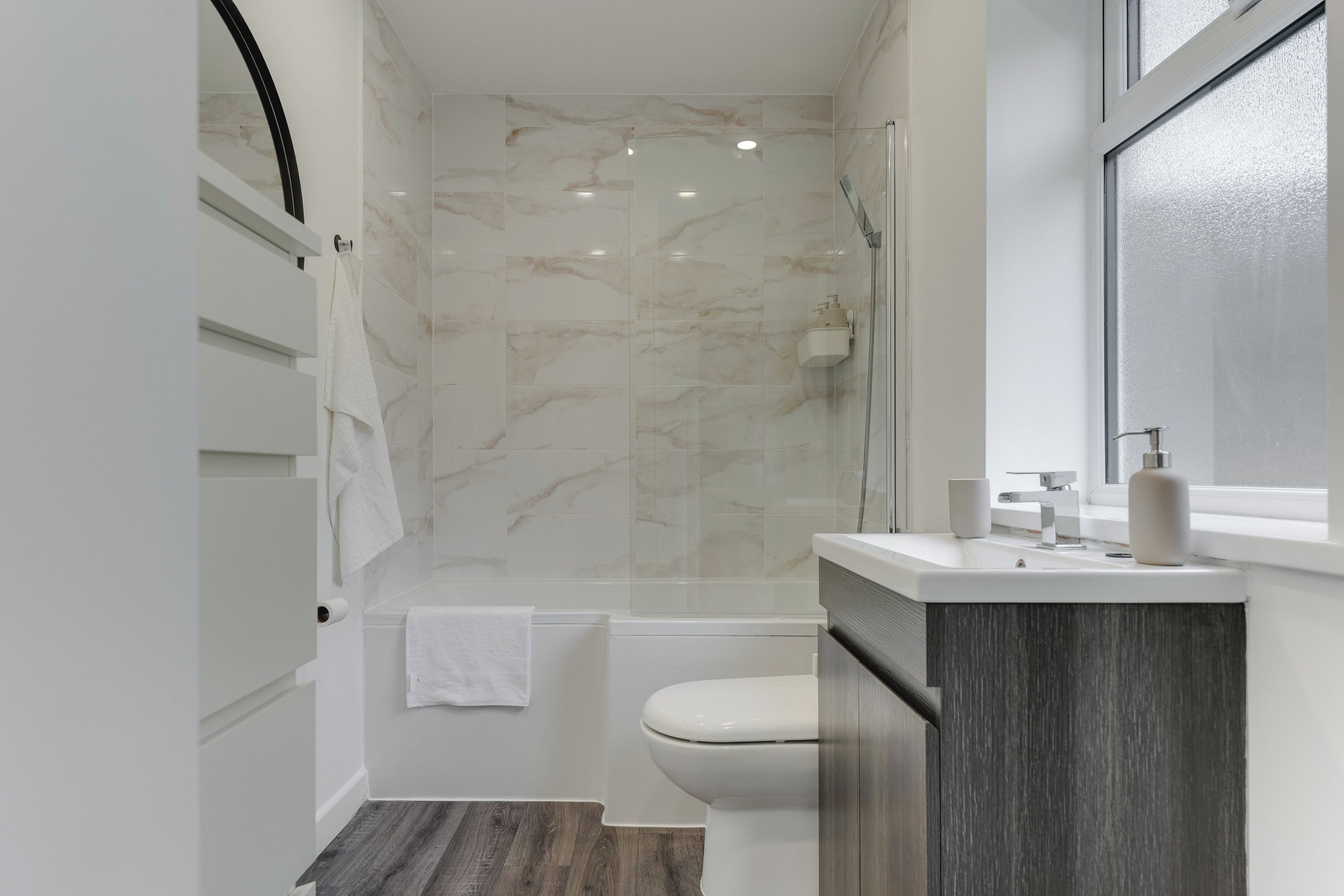 Bright modern bathroom with marble-look tiles and sleek vanity