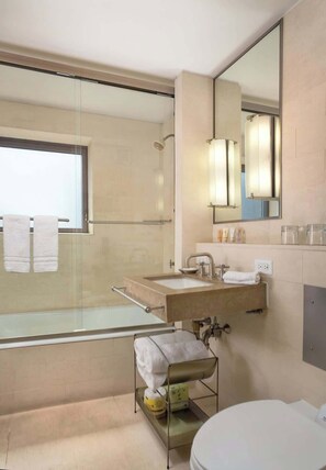 Un baño moderno con cabina de ducha de vidrio, un lavamanos con toallero y un inodoro.