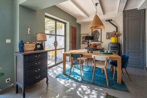 Un comedor con mesa de madera, sillas y alfombra azul.