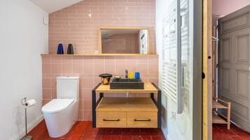 A compact bathroom with a toilet, sink, and shower.