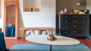 A room with a round table, a dresser, and a mirror.