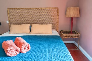 A bed with a blue blanket, two pillows, and two rolled towels. - Guest Room 'Suite 55' with Wi-Fi (Tulette)