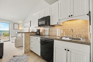 A modern kitchen with white cabinetry, a black dishwasher, a microwave, and a sink. - 🏖 Top-floor Bay-view 1BR @ The Shores Grand Traverse Resort Sleeps 6 (Williamsburg)