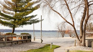 Ein Park am Wasser mit einem gepflasterten Weg, Bänken und Blick auf das Wasser.