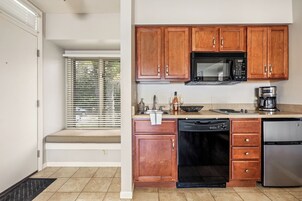 A kitchen with wooden cabinets, a microwave, a dishwasher, and a refrigerator.