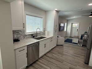 A modern kitchen with a dishwasher, a sink, and a window with blinds. - New Construction.  Sunny Escape Near Anna Maria : 3BR/2BA Home with Resort Pool! (Bradenton)