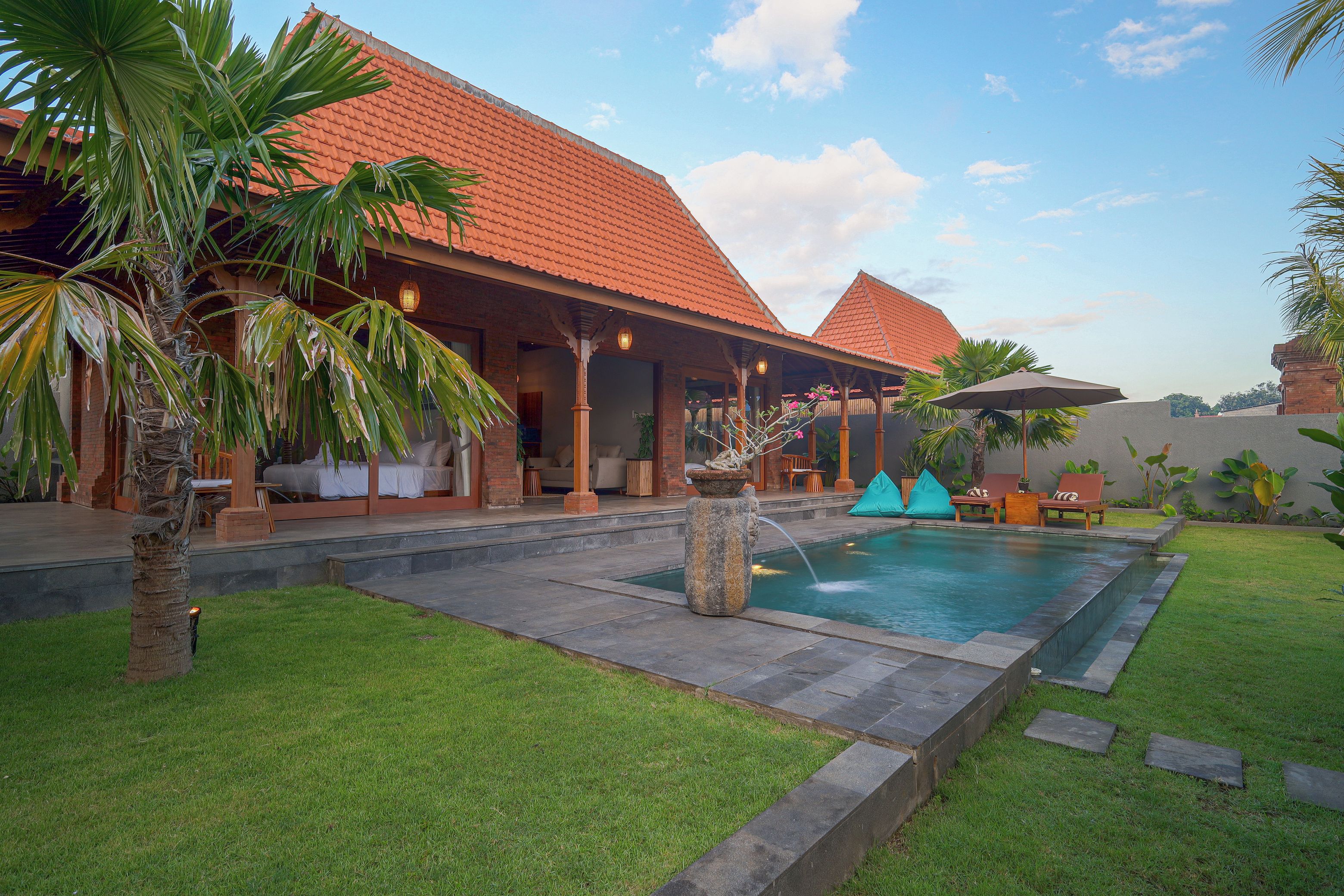 A resort with a swimming pool, outdoor seating, and a covered patio area.
