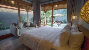 Ein Schlafzimmer mit einem großen Bett, einem Sofa und Blick auf Pool und Garten.