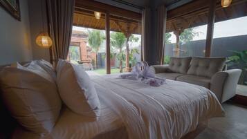 A hotel room with a bed, a sofa, and a view of the outdoors.