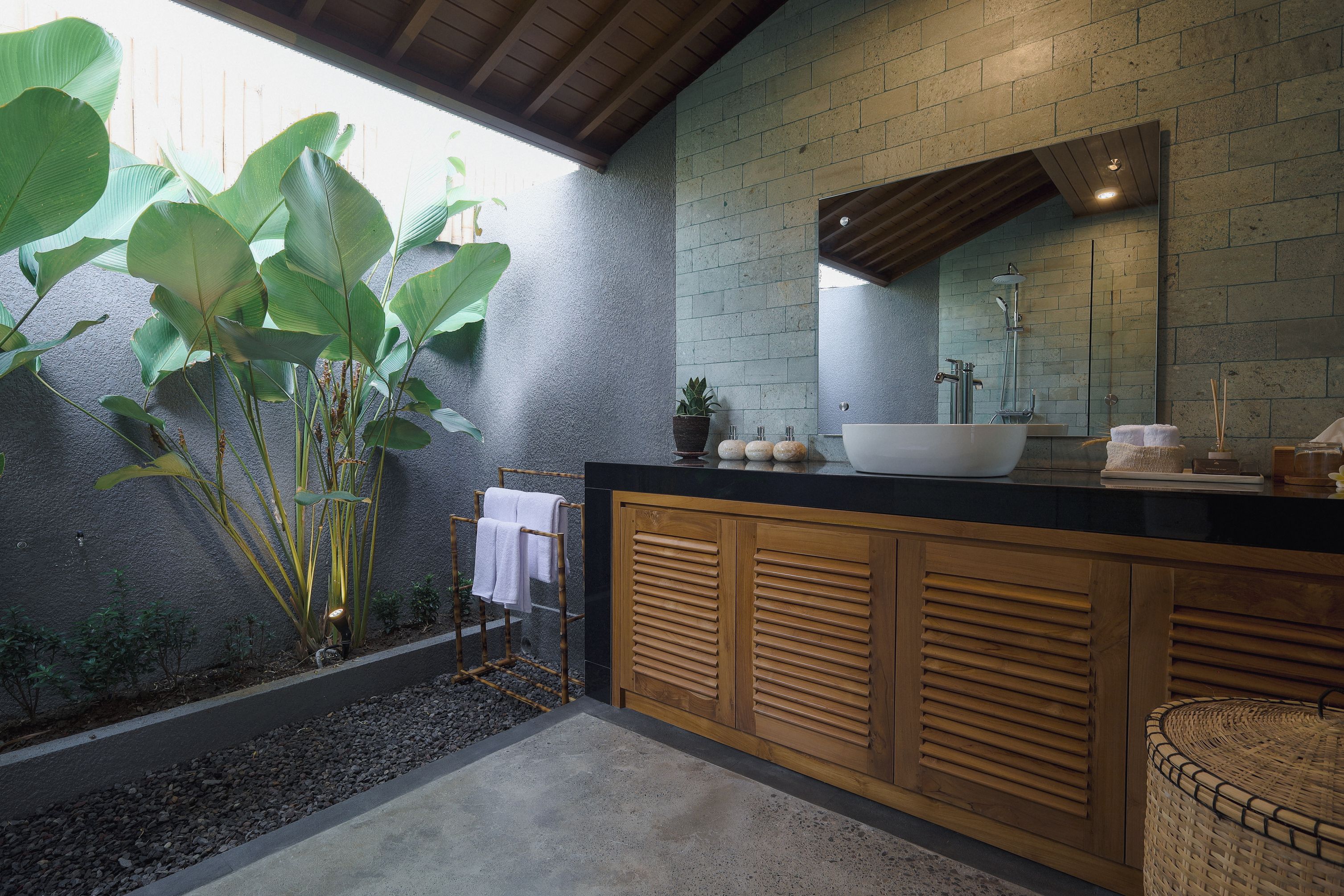 Un baño moderno con un espejo grande, un lavamanos blanco y un mueble de madera.