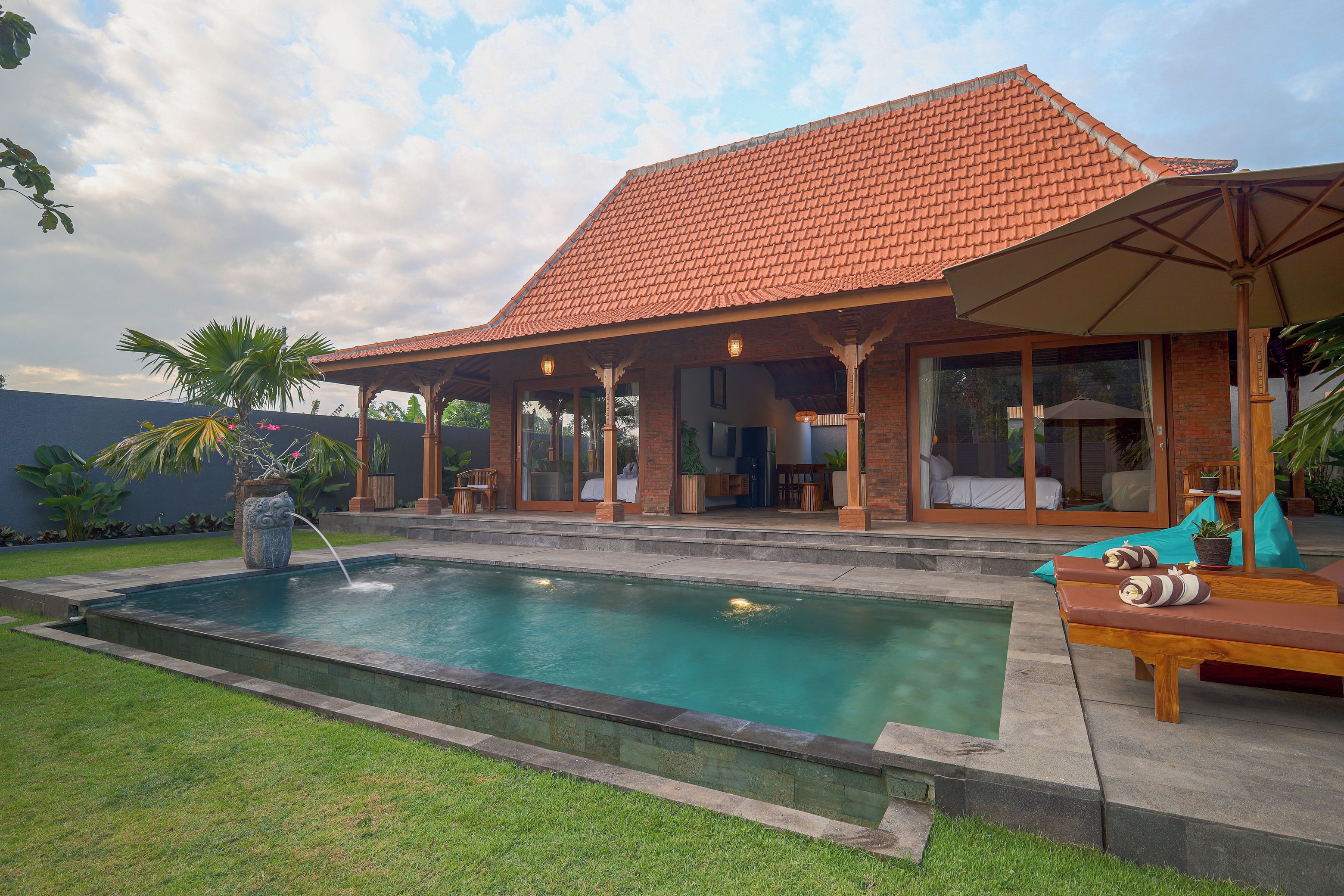 Una casa con piscina, terraza techada y zona de estar al aire libre.