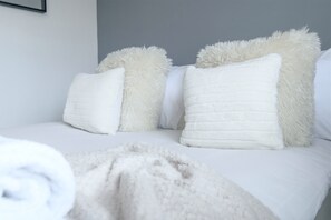 A bed with white bedding and fluffy pillows. - Maison Modern - Family-Friendly with Lovely Garden - Pass the Keys (Leeds)