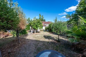 A backyard with a paved path leading to a house. - L'Appartement Parmentier - Proche Aéroport Orly (Montgeron)