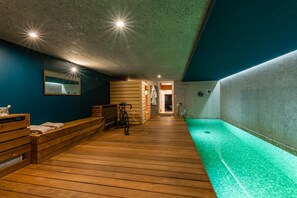 Wellnessbereich mit Holzliegen, einem Fahrrad und einem kleinen Pool.