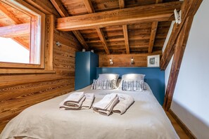 A room with a wooden ceiling, a bed with white linens, and a window. - Chalet Twin - Piscine Privée et Sauna (La Salle-les-Alpes)