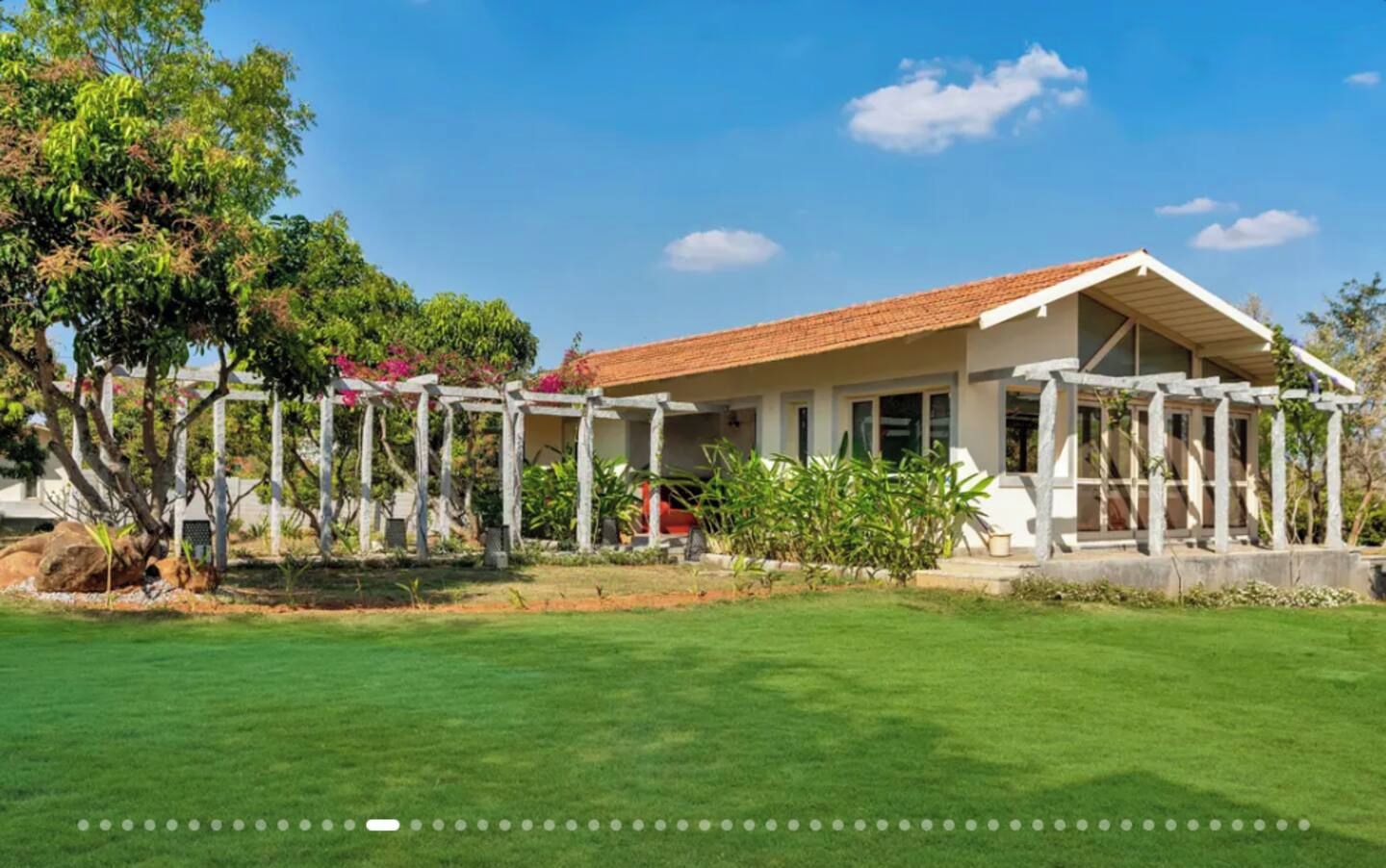 A two-story house with a tiled roof, a covered porch, and a well-maintained lawn.