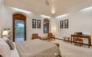 Una camera d'albergo con un letto, due sedie, una scrivania e un tavolino.