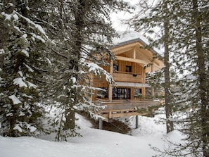 A wooden cabin with a balcony, surrounded by snow-covered trees. - Cabin in Turrach With Sauna and Balcony (Stadl-Predlitz)