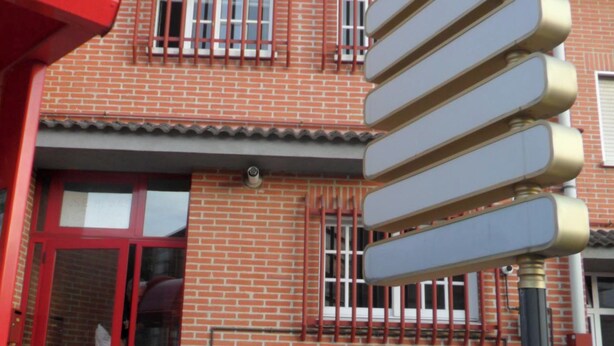 A red brick building with a signboard, a red door, and a potted plant. - Bright house with good transportation access (Algete)