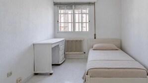 Une chambre à coucher avec un lit, un bureau et un radiateur.