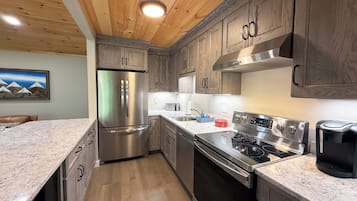 A modern kitchen with wooden cabinets, stainless steel appliances, and a granite countertop.