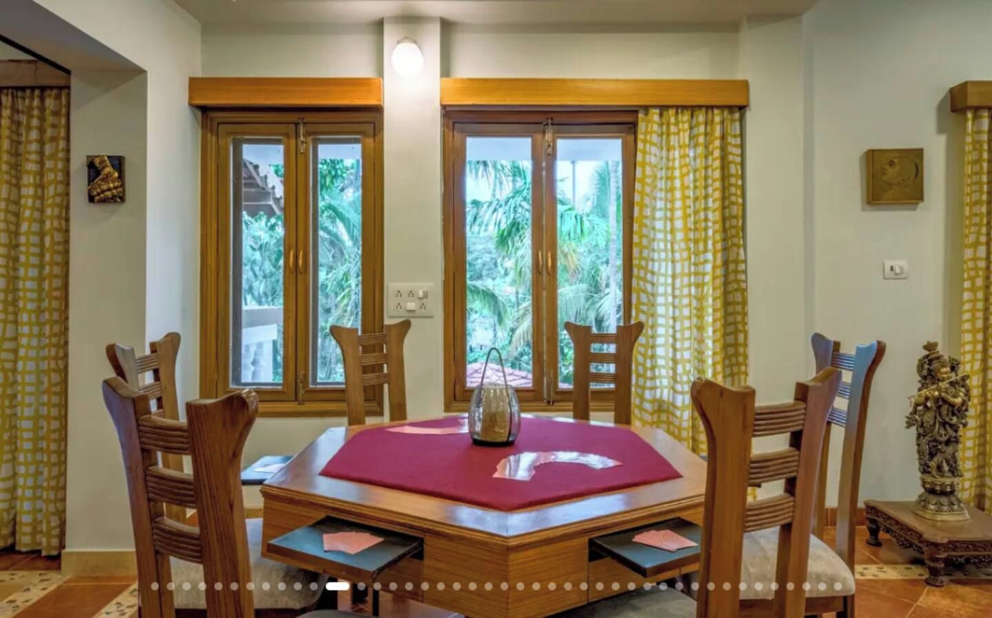 Comedor con mesa de madera, sillas y vistas amplias a través de grandes ventanales.