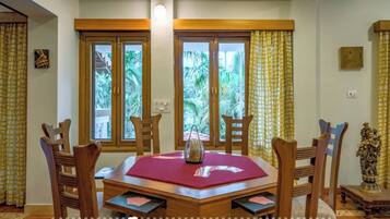 Comedor con mesa de madera, sillas y vistas amplias a través de grandes ventanales.