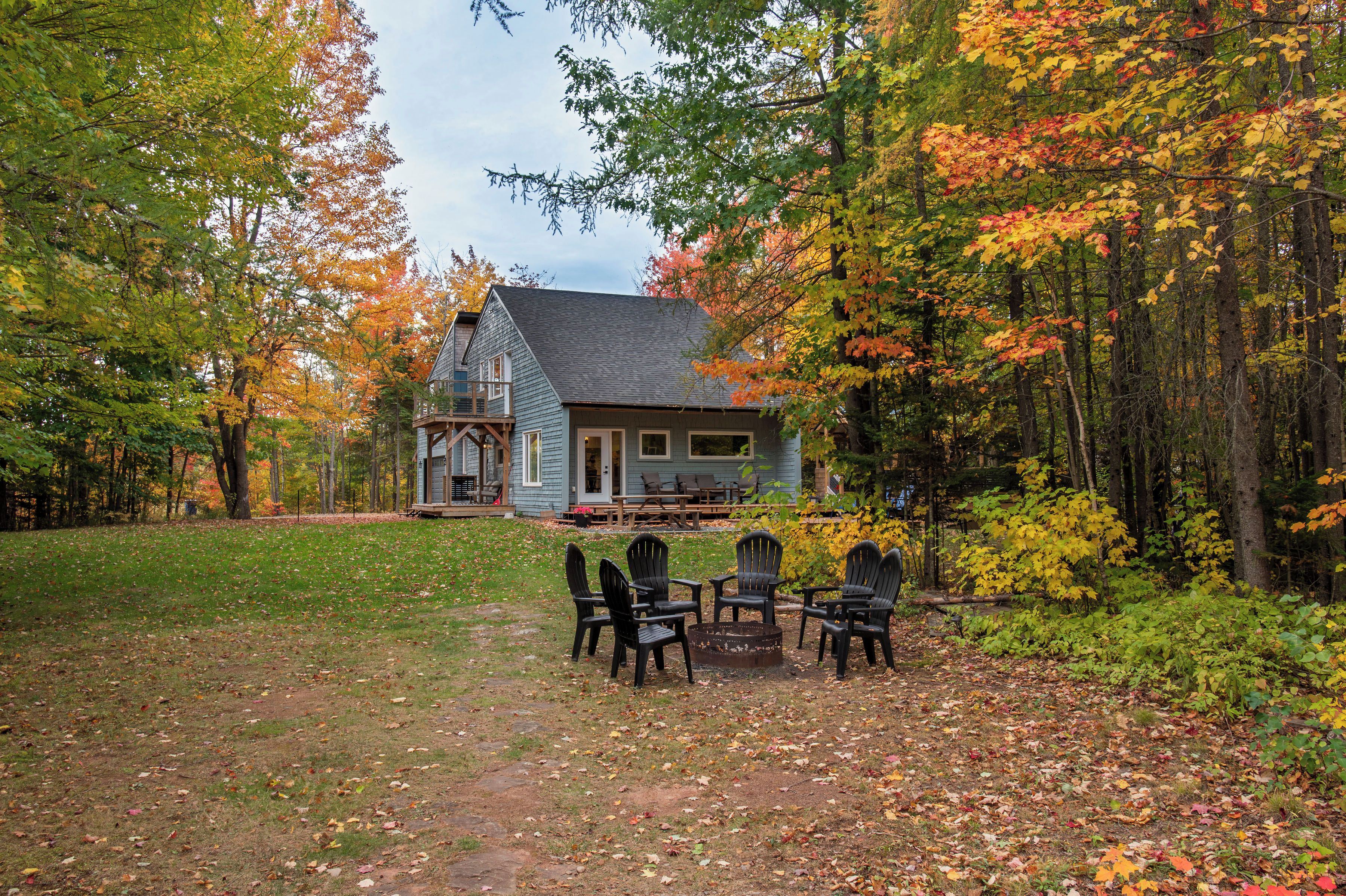 A house with a porch, surrounded by trees with autumn foliage.