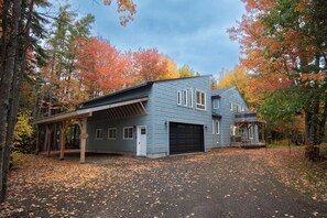 A two-story house with a covered porch and a garage. - Lakefront Retreat/5 BR/Games Room/Beach/Karaoke (Canning)