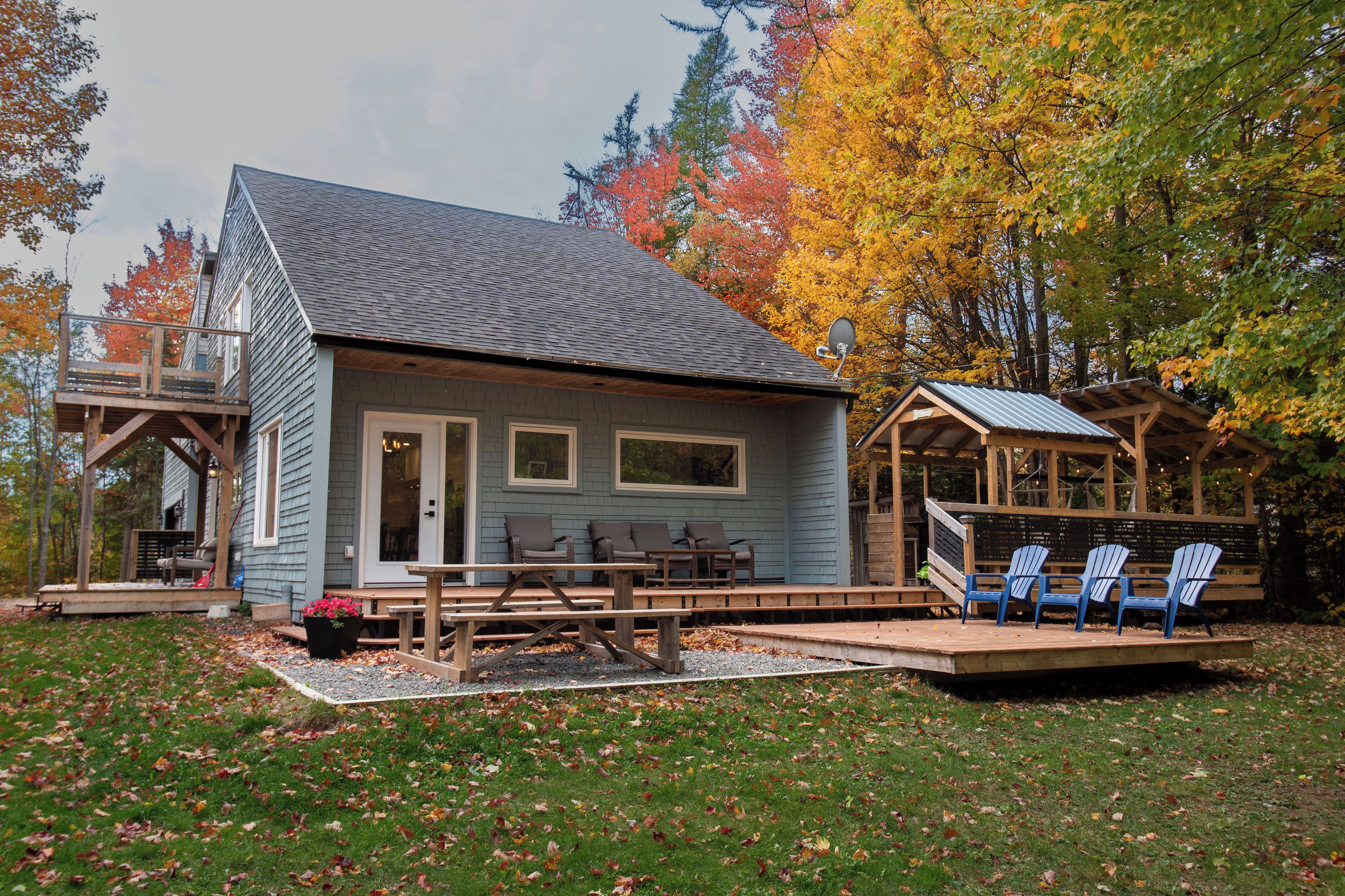 A cabin with a porch, outdoor seating, and a deck.