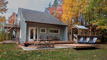 A cabin with a porch, outdoor seating, and a deck.