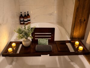 A bathroom with a wooden bench, a potted plant, candles, and toiletries. - Lakefront Retreat/5 BR/Games Room/Beach/Karaoke (Canning)