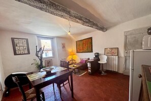 A cozy living room with a dining table, a sofa, a lamp, and a radiator.