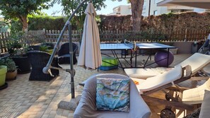 A patio with outdoor furniture, including a table and chairs, a swing, and a sun lounger. - Cozy 2-room apartment on the first floor in a quiet complex with a pool (Antibes)