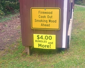 A sign indicating firewood is available for purchase at $4.00 bundles and more.