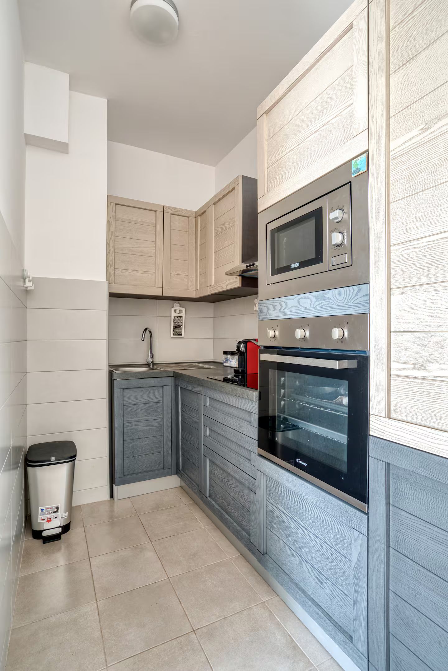 A compact kitchen with a microwave, oven, and a coffee maker.