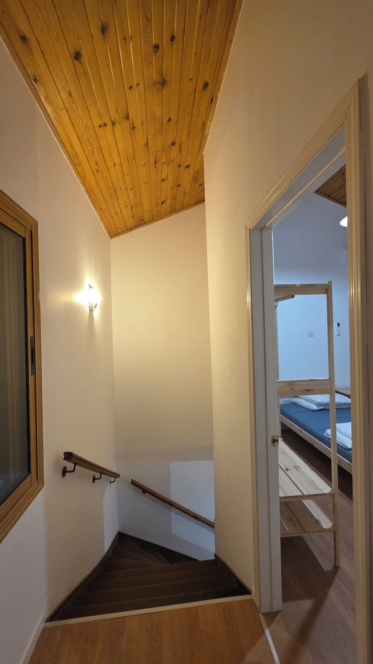 Una scala con gradini in legno che conduce a una stanza con un letto.