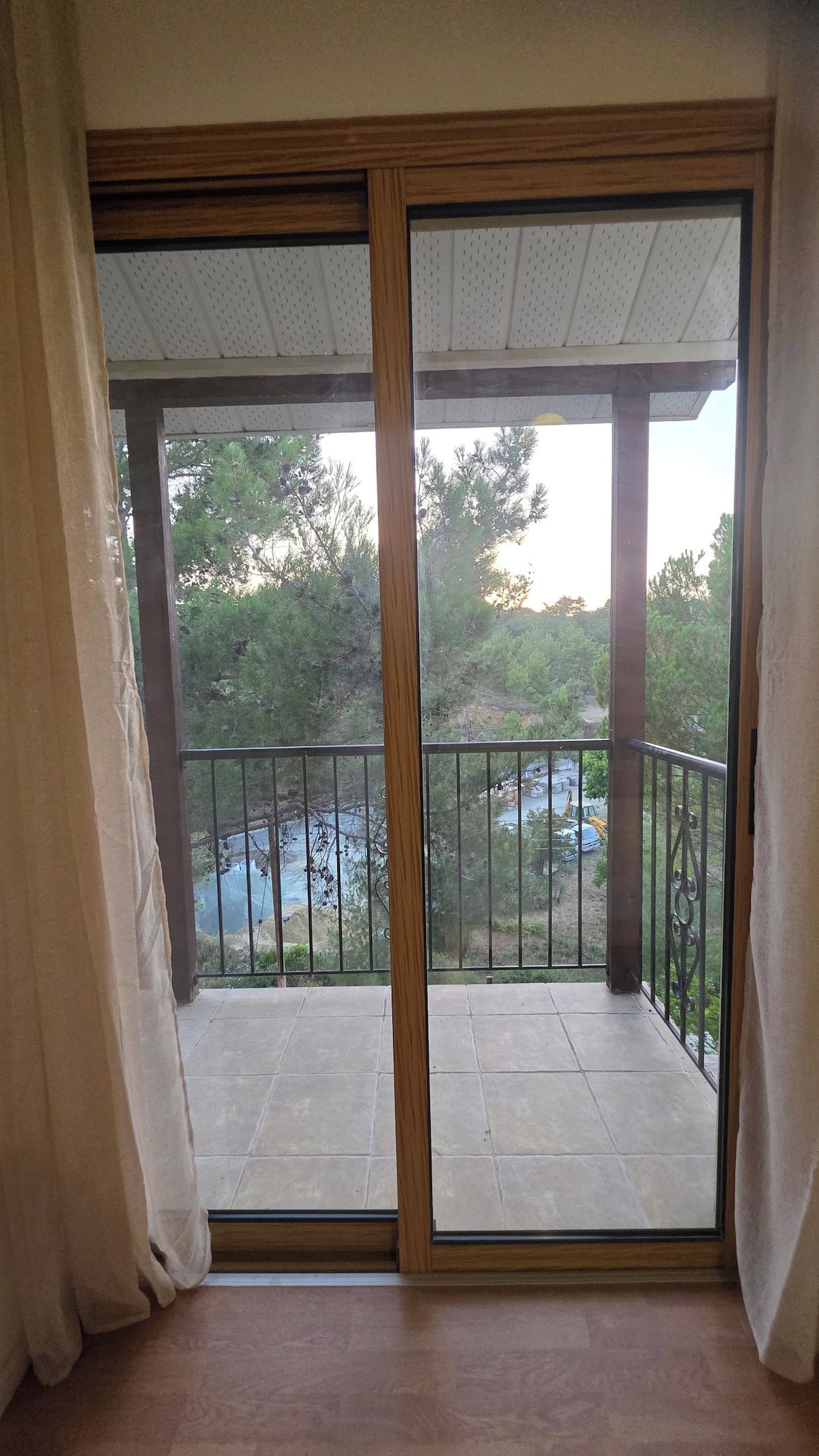 A room with a sliding glass door leading to an outdoor balcony with a metal railing.