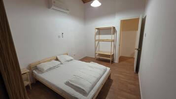 A bedroom with a wooden bed, a built-in wardrobe, and a ceiling fan.
