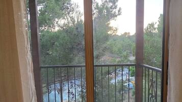 A room with a sliding glass door leading to an outdoor balcony with a metal railing.