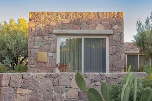A stone building with a large window and a plaque.