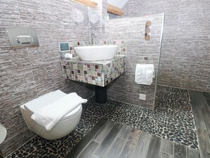 A bathroom with a white bathtub, a toilet, a sink with a mosaic tile backsplash, and a shower area. - The Apple Store at Gileston Manor (Barry)