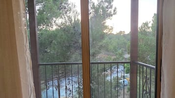 A room with a sliding glass door leading to an outdoor balcony with a metal railing.
