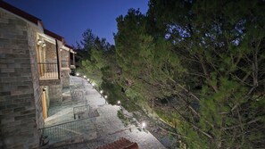 Un edificio de piedra con una escalera que conduce a un balcón, rodeado de árboles.