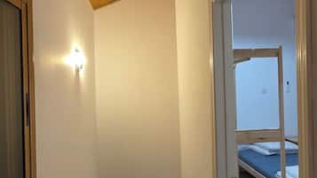 A staircase with wooden steps leading to a room with a bed.