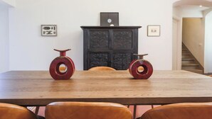 A dining table with two decorative vases, a dark wooden cabinet, and a staircase in the background. - ALFIERI PRESTIGE – SPACIOUS FLORENCE PENTHOUSE WITH DUOMO VIEWS (Firenze)