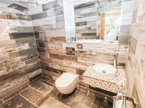 A modern bathroom with a shower, toilet, and sink. - The Stalls at Gileston Manor (Barry)