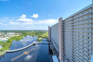 A high-rise hotel with a view of a river and greenery. - Laketown Wharf 1731 (Panama City Beach)